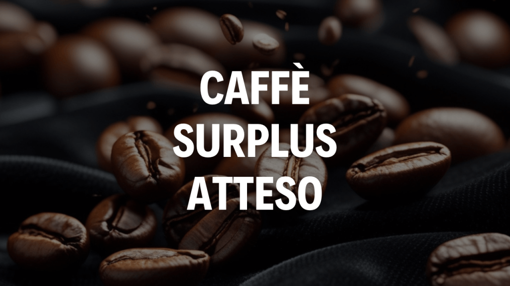 Prezzo del caffè in calo: pesano surplus atteso e produzione brasiliana immagine di chicchi di caffè con scritta bianca Caffè surplus atteso